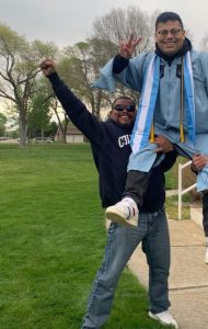 Carlos Godinez ayuda a alzar a su hermano Jonathan tras su graduación con una maestría de la Universidad de Columbia. (Cortesía de la familia Godinez)